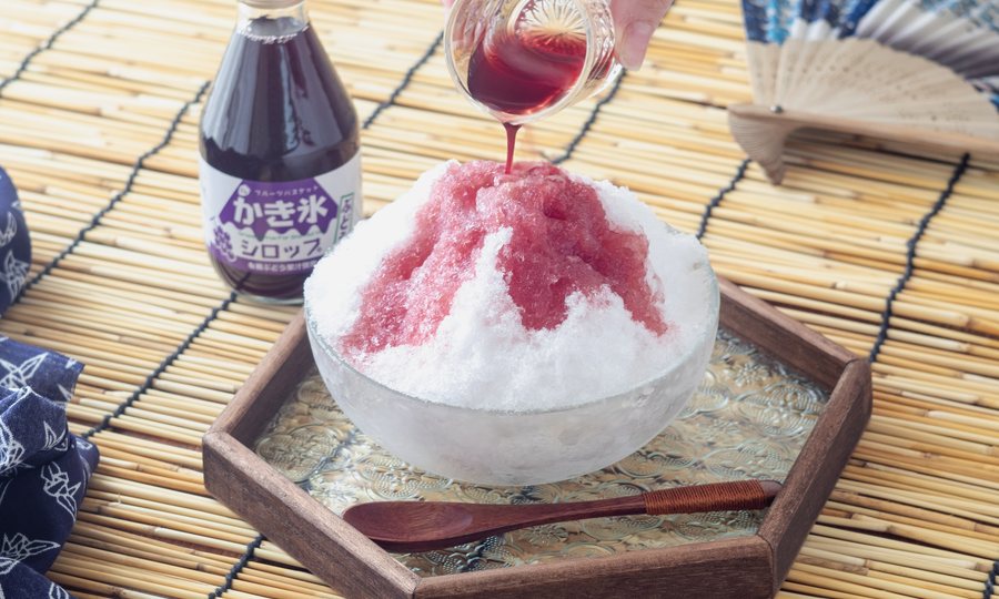 ぶどうシロップをかき氷にかける様子